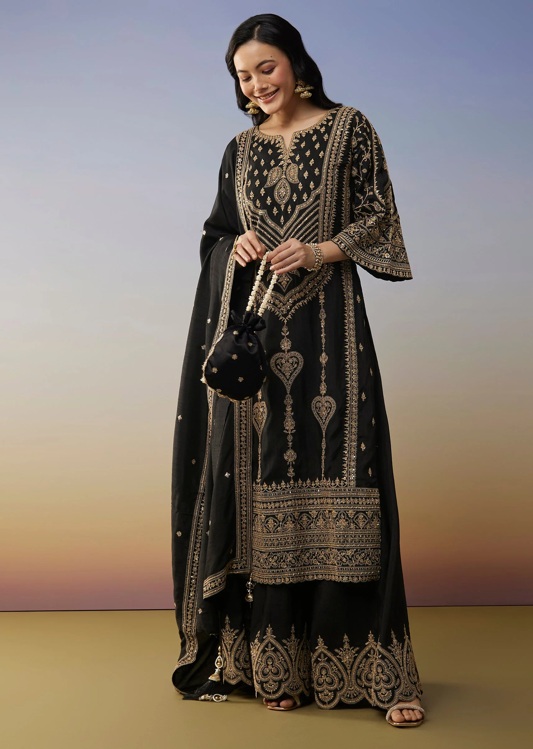 Bold Festive Couple Set – Black Silk Palazzo Suit With Zari Thread And Sequins Work For Her And Black Suiting Jodhpuri Pant Set With Embroidery For Him - Image 3