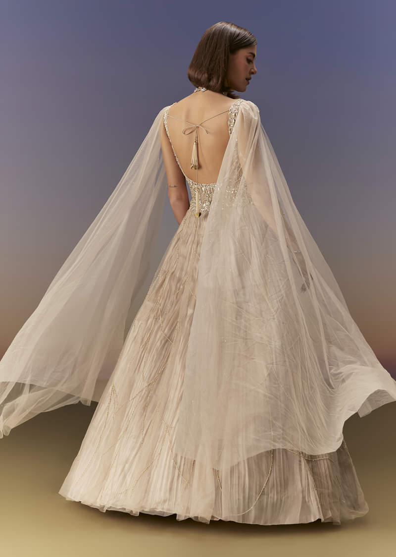 Gold Gown With Pleated Panels And Dramatic Cape - Image 2